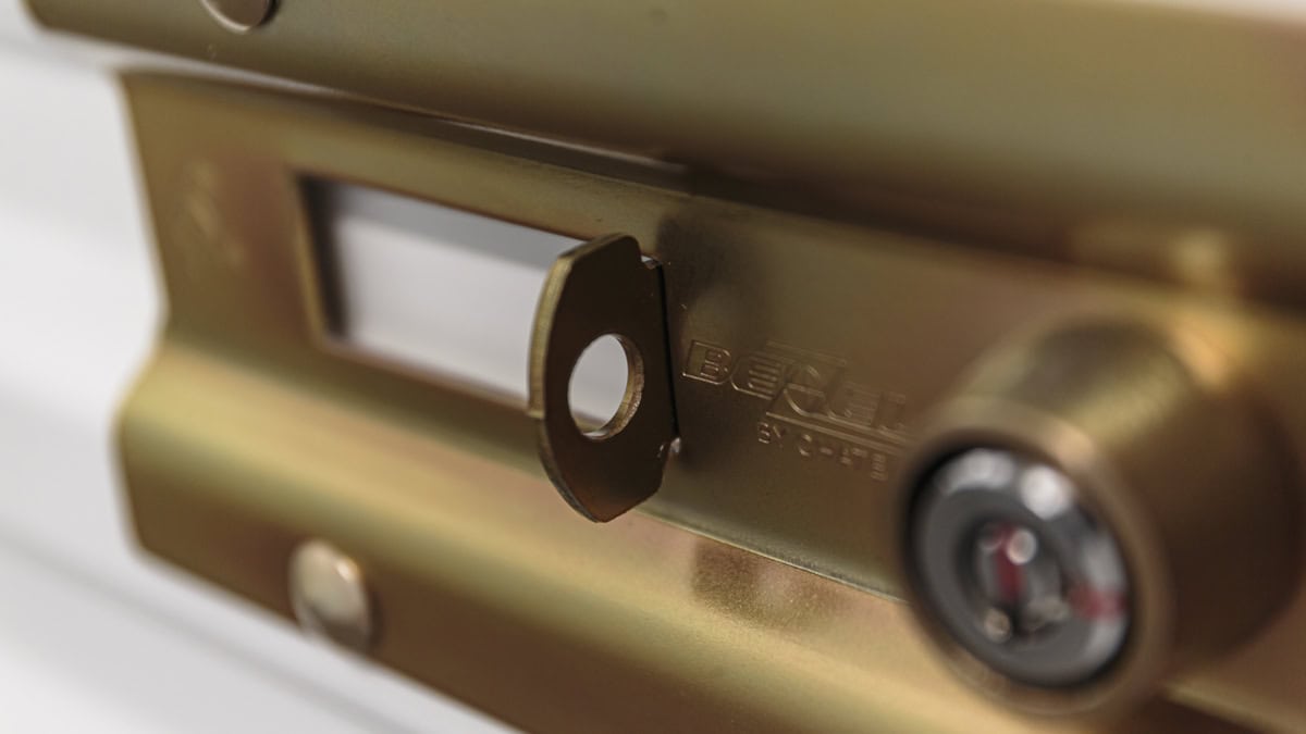 Close-up of a gold-colored garage door lock with keyhole for security.