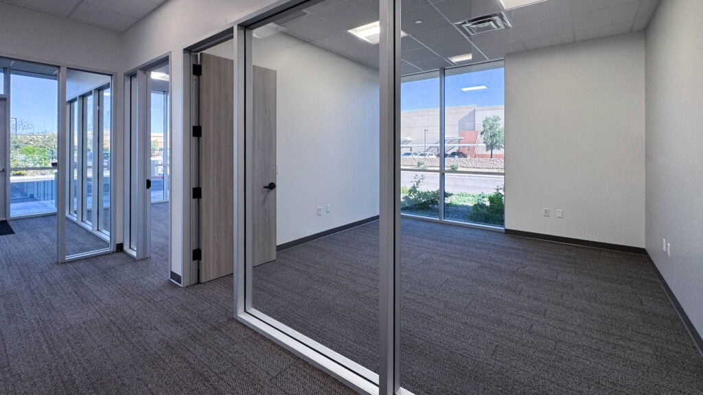 Modern commercial office with glass walls, natural lighting, and professional workspace design.